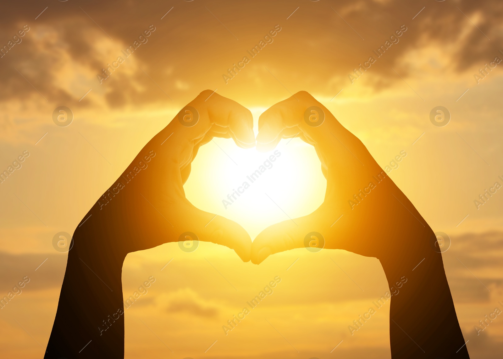 Image of Hope. Sun shining through heart made of woman's hands against sunrise sky, closeup