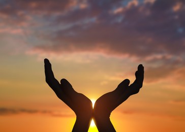 Image of Hope. Woman holding hands against sky with clouds and sun, closeup