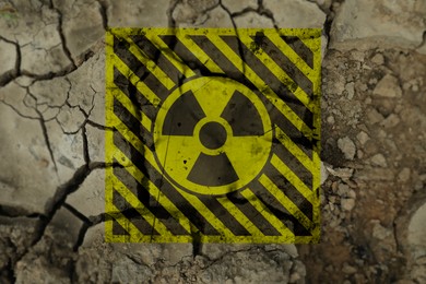 Image of Yellow radioactive sign on cracked dry earth, top view. Radiological pollution