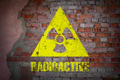 Image of Yellow radioactive sign on old brick wall. Radiological pollution