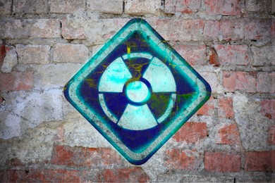 Image of Bright radioactive sign on old brick wall. Radiological pollution