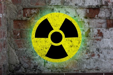 Image of Yellow radioactive sign on old brick wall. Radiological pollution