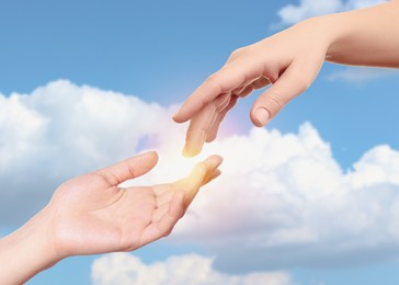 Image of Hope. Women holding hands against blue sky with clouds, closeup