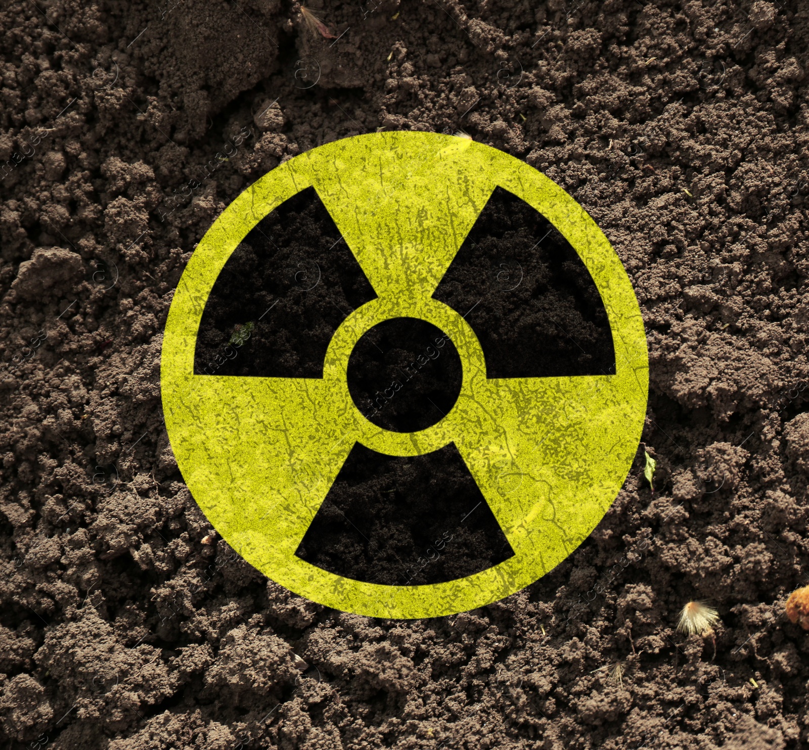 Image of Yellow radioactive sign on soil, top view. Radiological pollution