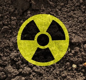 Image of Yellow radioactive sign on soil, top view. Radiological pollution