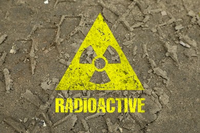 Image of Yellow radioactive sign on ground with tire tracks, closeup. Radiological pollution