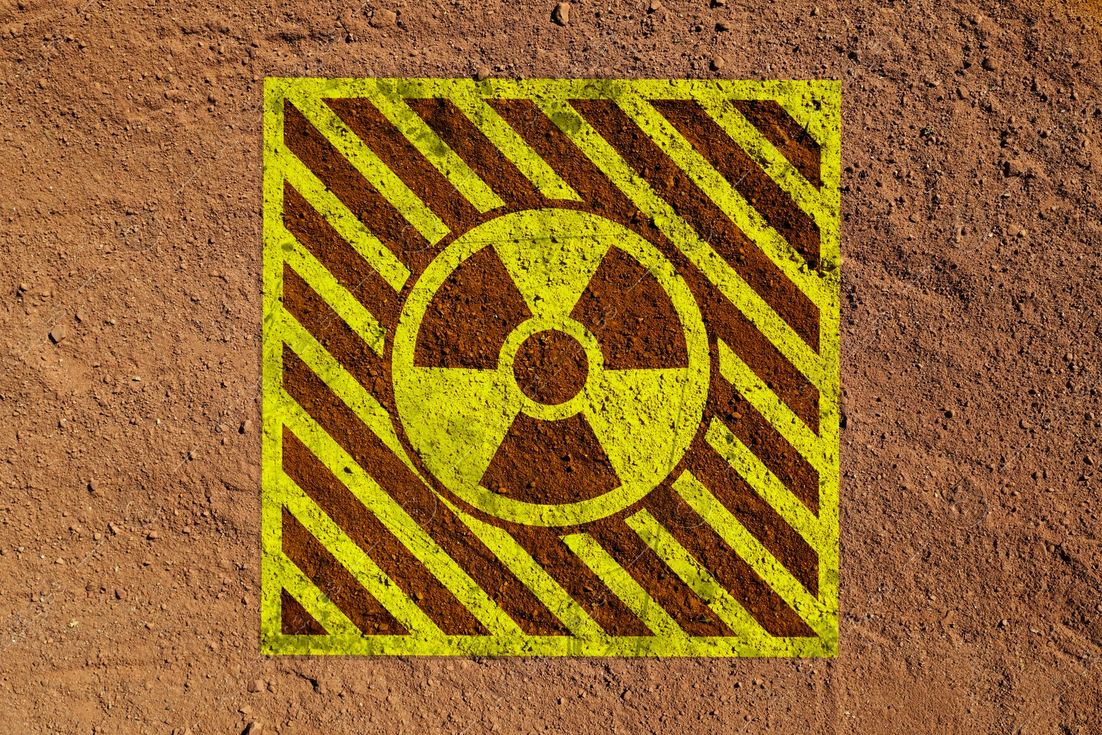Yellow radioactive sign on brown ground, top view. Radiological pollution Image of Yellow radioactive sign on brown ground, top view. Radiological pollution