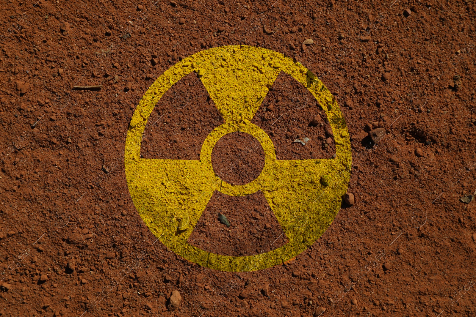 Radioactive sign on brown ground, top view. Radiological pollution Image of Radioactive sign on brown ground, top view. Radiological pollution