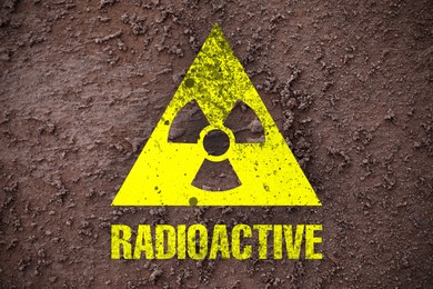 Image of Yellow radioactive sign on brown ground, top view. Radiological pollution