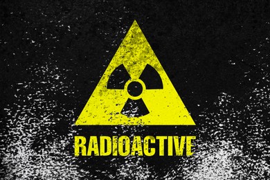 Image of Radioactive sign on black textured surface. Radiological pollution