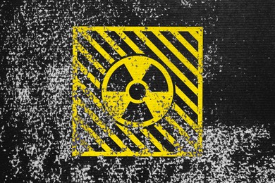 Image of Radioactive sign on black textured surface. Radiological pollution