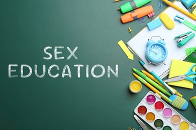 Image of Sex Education inscription and stationery on green chalkboard, top view