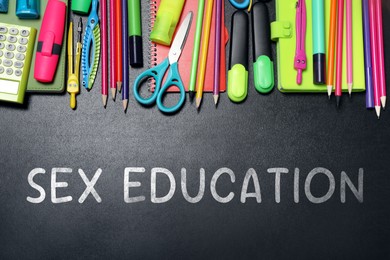 Image of Sex Education inscription and stationery on black chalkboard, top view