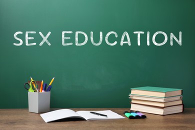 Image of Sex Education inscription on green chalkboard and stationery on wooden desk