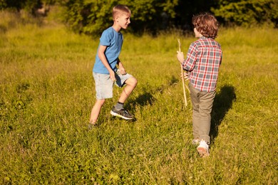 Photo of Cute little boys playing in nature on sunny day