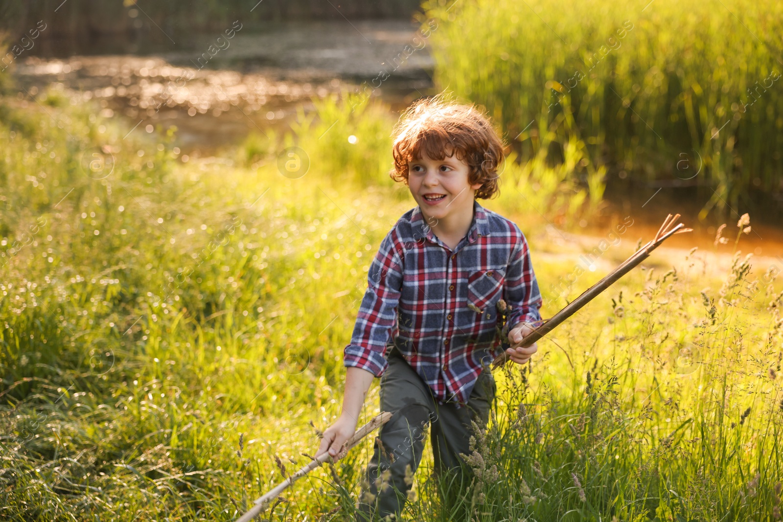 Cute little boy playing with wooden sticks in nature Photo of Cute little boy playing with wooden sticks in nature