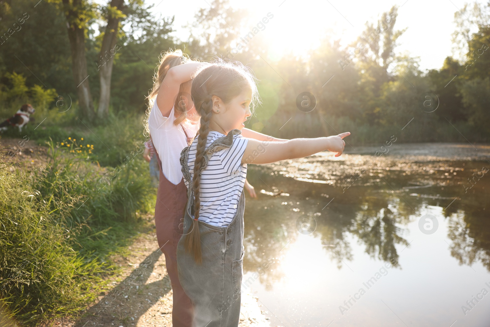 Cute little girls spending time by lake in nature Photo of Cute little girls spending time by lake in nature