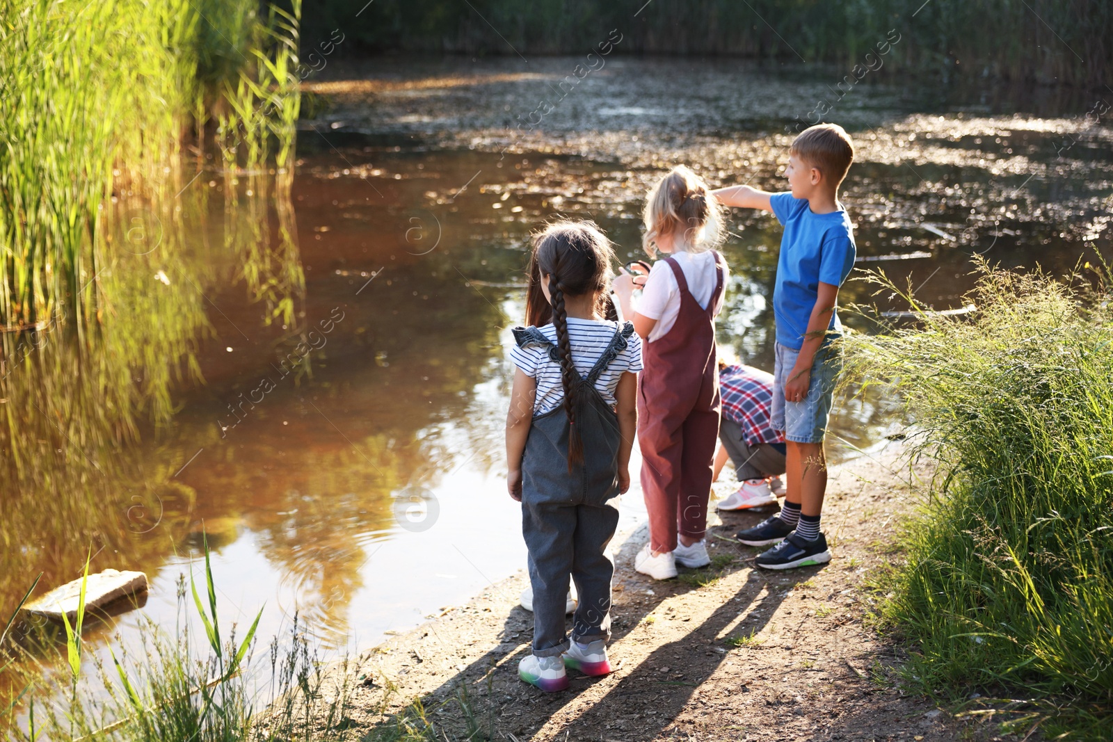 Children spending time by lake in nature Photo of Children spending time by lake in nature