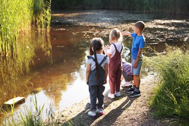 Photo of Children spending time by lake in nature