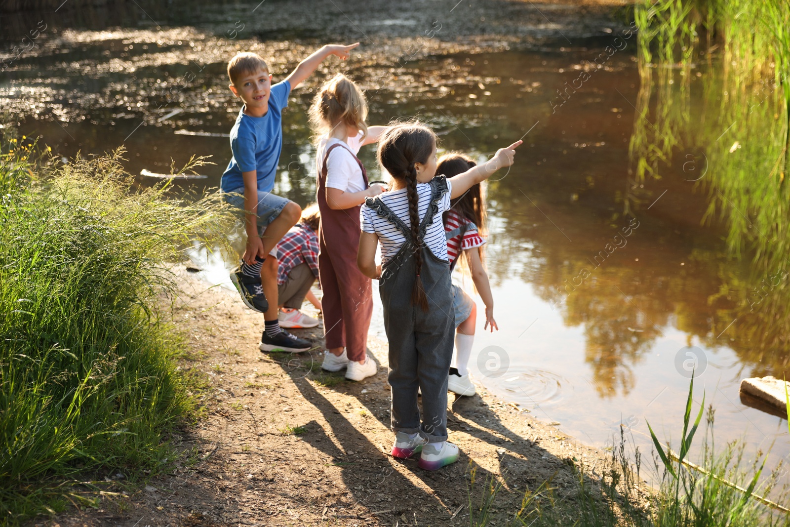 Children spending time by lake in nature Photo of Children spending time by lake in nature