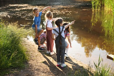 Photo of Children spending time by lake in nature