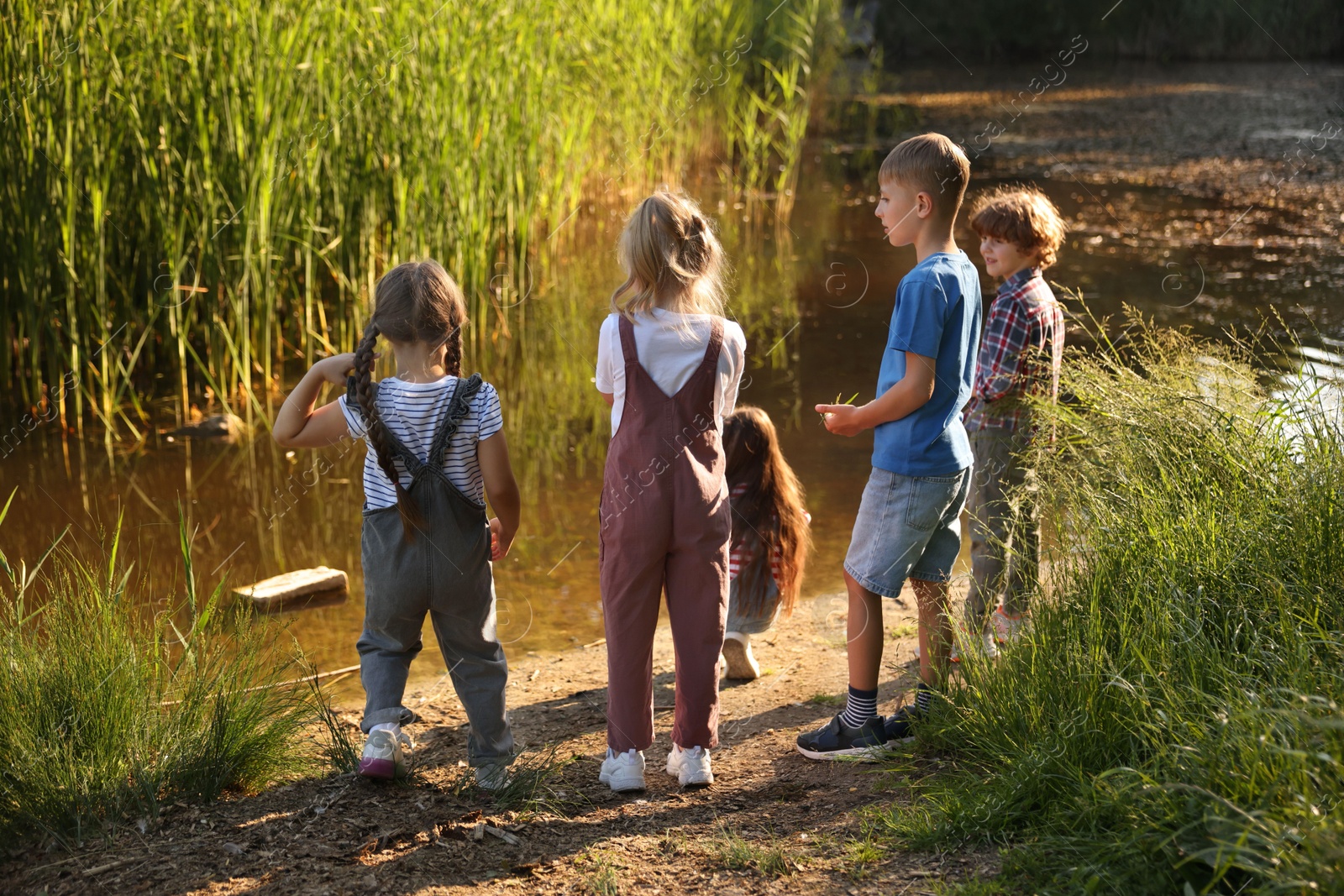 Children spending time by lake in nature Photo of Children spending time by lake in nature