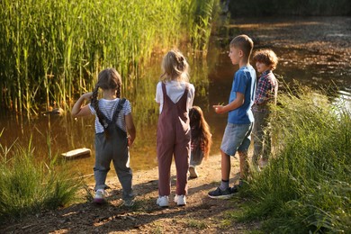 Photo of Children spending time by lake in nature