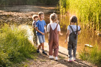 Photo of Children spending time by lake in nature