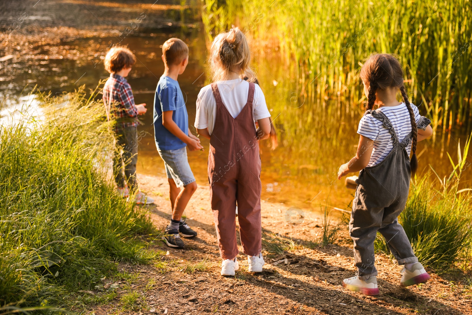 Photo of Children spending time by lake in nature