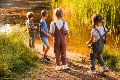 Photo of Children spending time by lake in nature