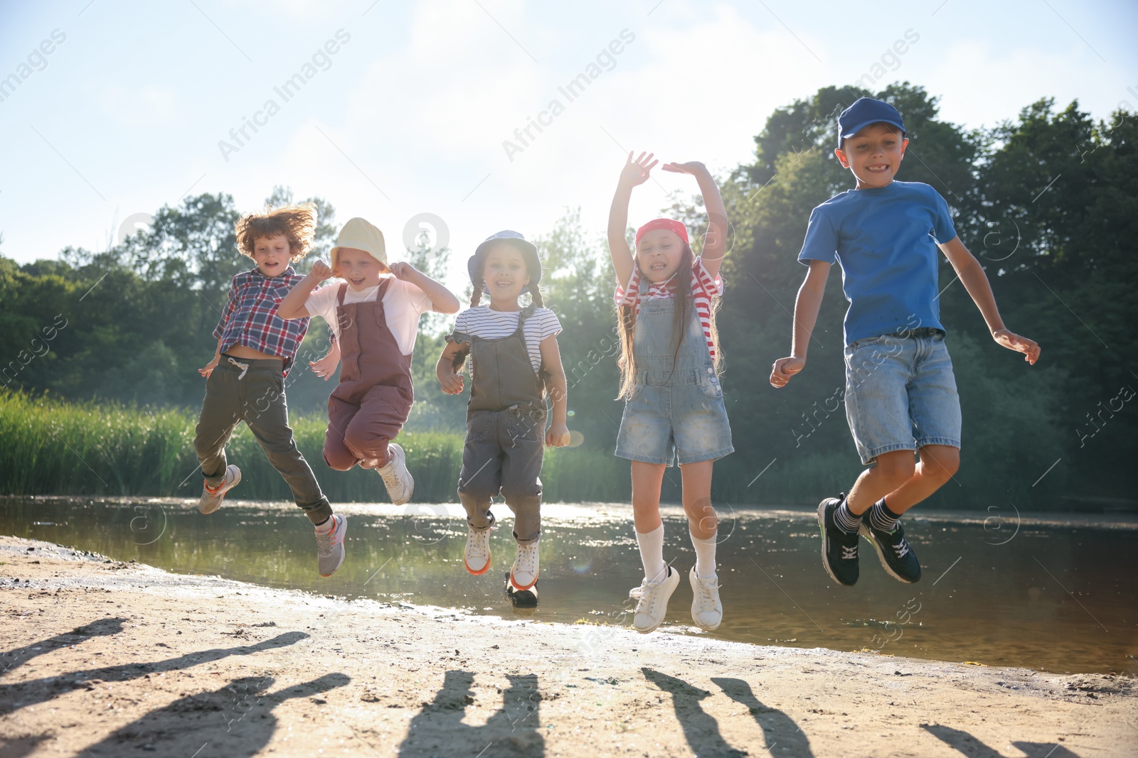 Happy children jumping in nature on sunny day Photo of Happy children jumping in nature on sunny day
