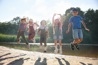 Photo of Happy children jumping in nature on sunny day