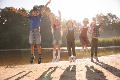 Photo of Happy children jumping in nature on sunny day