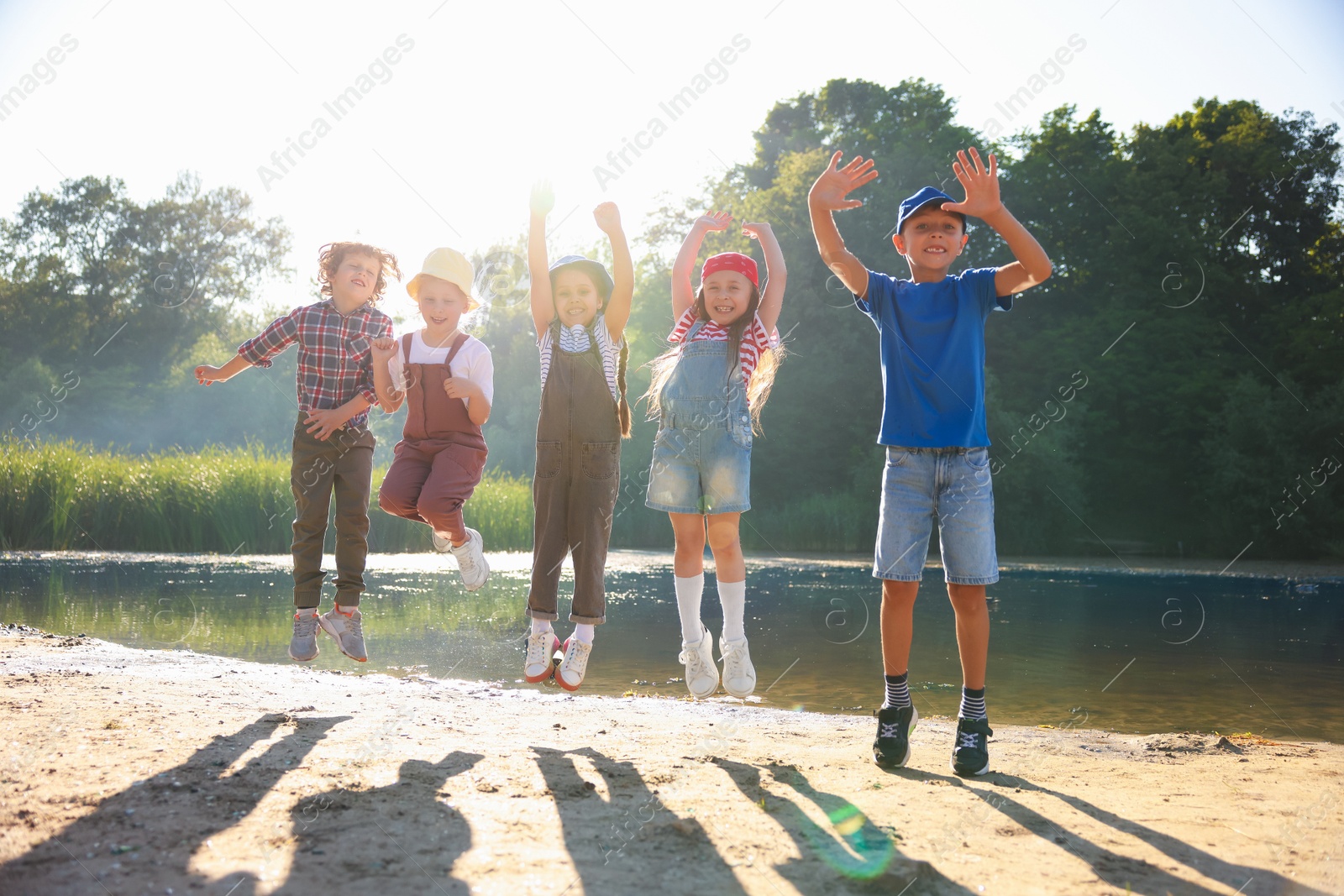 Happy children jumping in nature on sunny day Photo of Happy children jumping in nature on sunny day