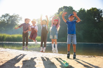 Photo of Happy children jumping in nature on sunny day