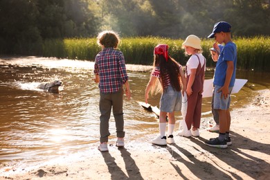 Photo of Children and dog with wooden stick in nature