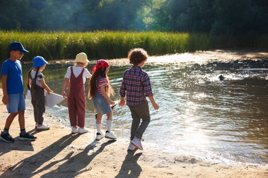 Photo of Children spending time by lake in nature