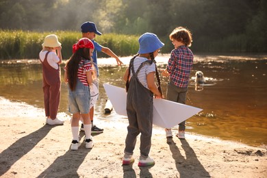 Photo of Children spending time by lake in nature