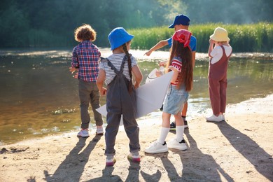 Photo of Children spending time by lake in nature