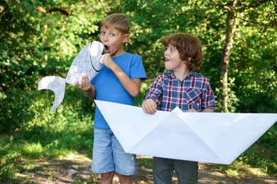 Photo of Children with paper boat and fish in nature