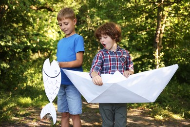 Photo of Children with paper boat and fish in nature