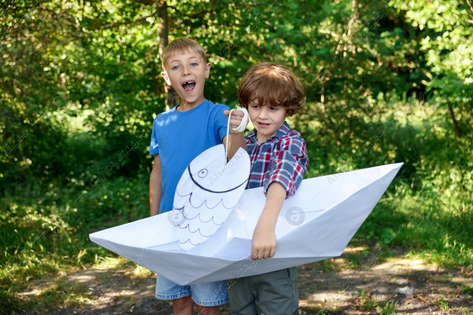 Children with paper boat and fish in nature Photo of Children with paper boat and fish in nature