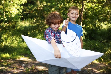 Photo of Children with paper boat and fish in nature