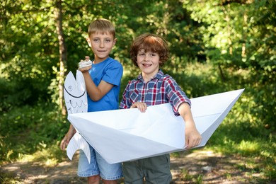 Photo of Children with paper boat and fish in nature