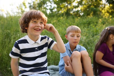 Photo of Children spending time in nature on summer day, selective focus