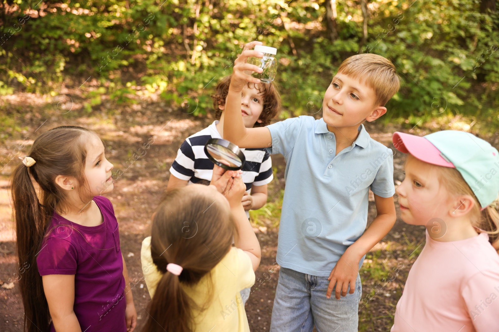 Children with jar and magnifying glass in nature Photo of Children with jar and magnifying glass in nature