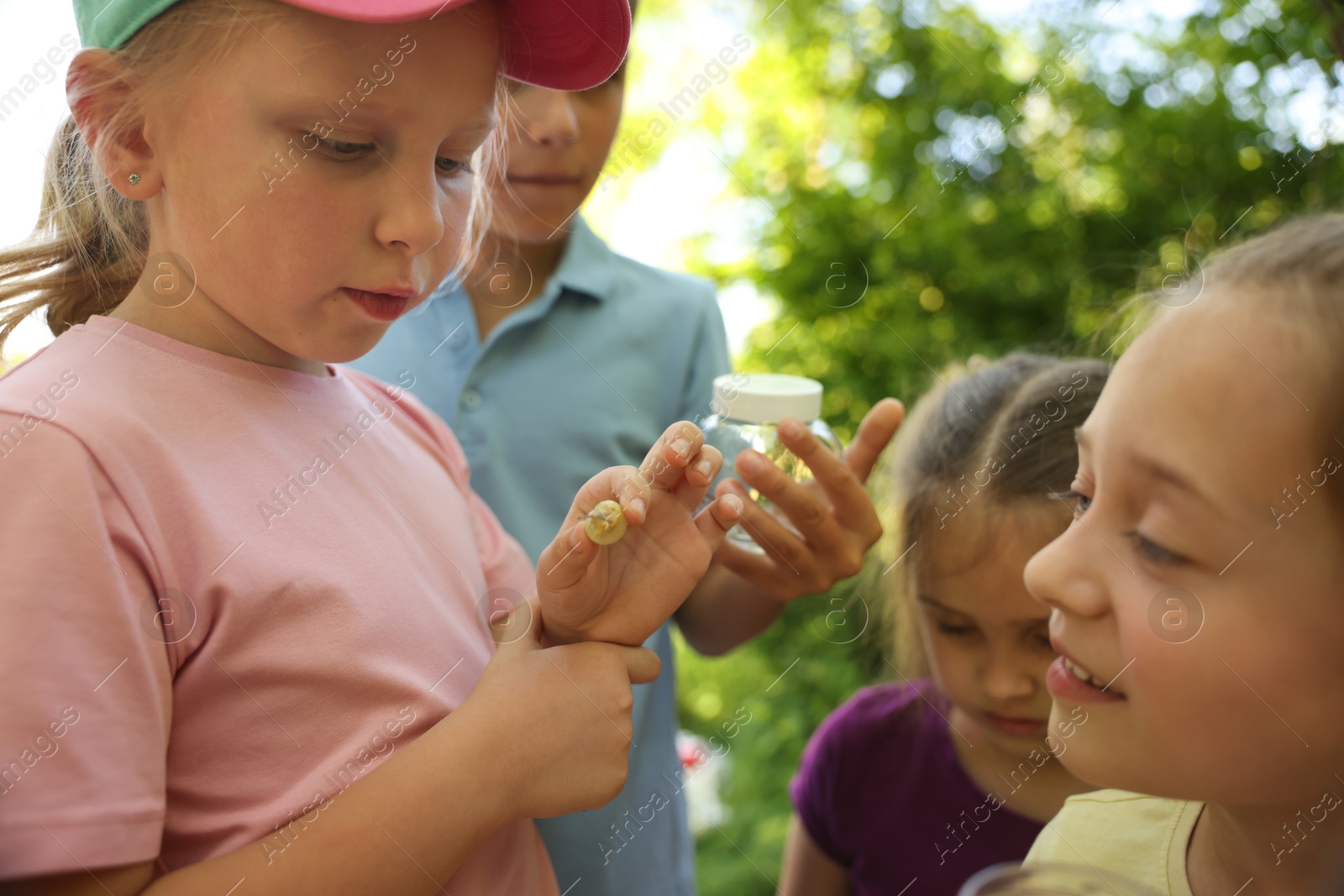 Children in nature. Cute little girl with snail outdoors, selective focus Photo of Children in nature. Cute little girl with snail outdoors, selective focus