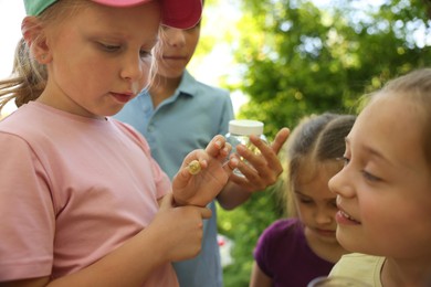 Photo of Children in nature. Cute little girl with snail outdoors, selective focus