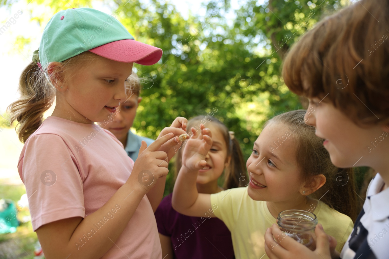 Children in nature. Cute little girl with snail outdoors, selective focus Photo of Children in nature. Cute little girl with snail outdoors, selective focus