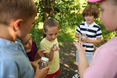 Photo of Children with snail and jars in nature